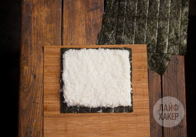 Kako narediti suširito: Na preprogo položite list nori in ga prekrijte s plastjo riža